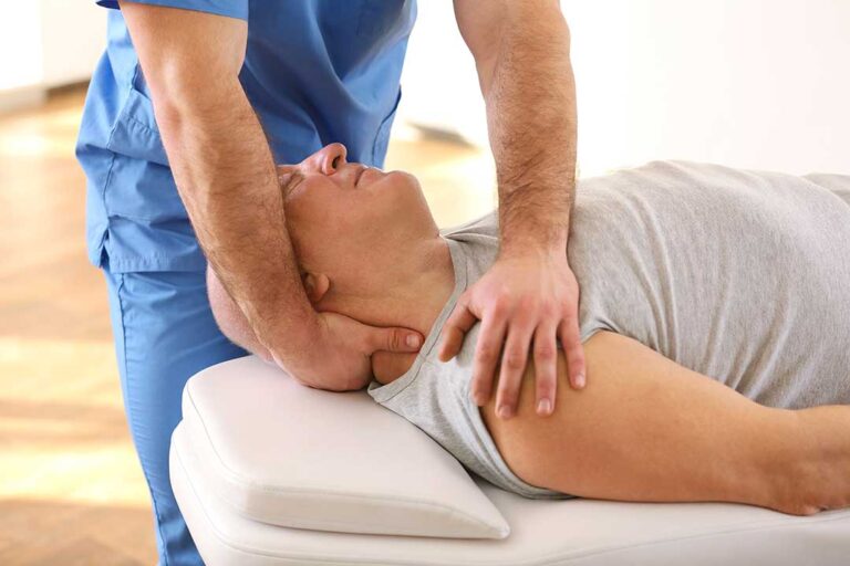 Adult seated in a car with one hand supporting a sore neck while reviewing accident symptoms.