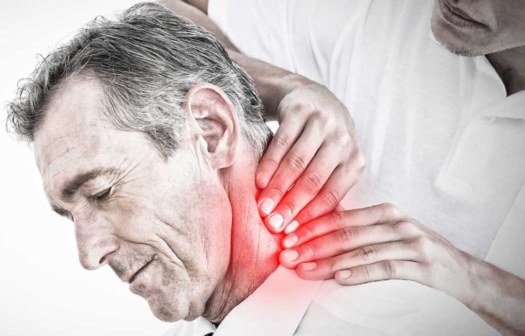 Person discussing back stiffness with a clinician during a posture and mobility examination in a bright room.