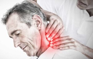 Person discussing back stiffness with a clinician during a posture and mobility examination in a bright room.